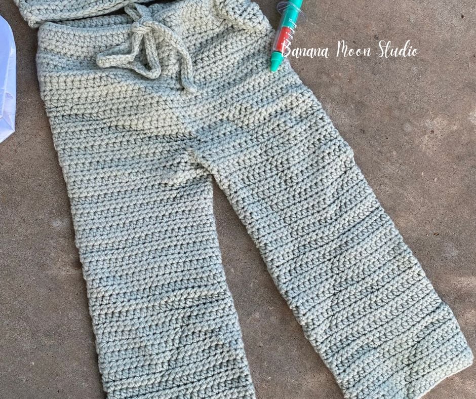 Crochet children's costume drawstring pants in pale green to look like medical scrubs. Text on the image reads: Banana Moon Studio.