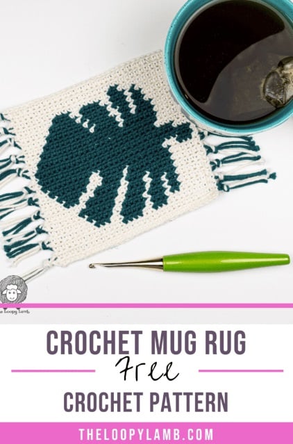 A crochet mug rug on a white surface with a cup of coffee and a green crochet hook. The mug run has a white background with a monstera leaf worked into it using intarsia. The edges of the mug rug are finished with fringe. Text and logo on the image read: The Loopy Lamb. White and pink panels with text read: Crochet mug rug. Free crochet pattern. TheLoopyLamb.com.