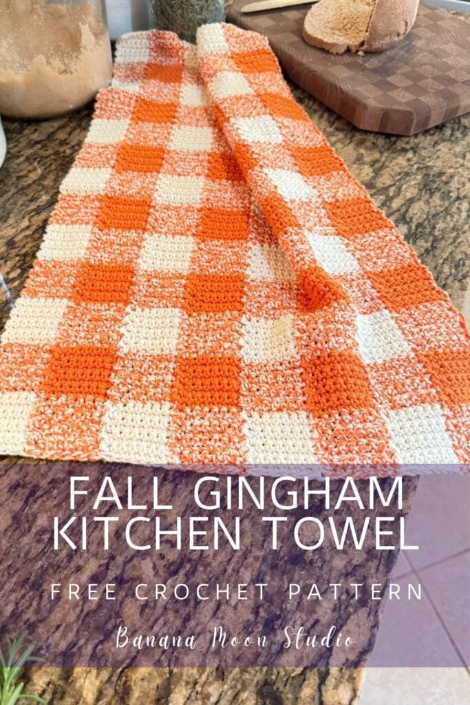 Orange and white crochet gingham kitchen towel on a granite countertop. A panel with text reads: Fall gingham kitchen towel free crochet pattern, banana moon studio.