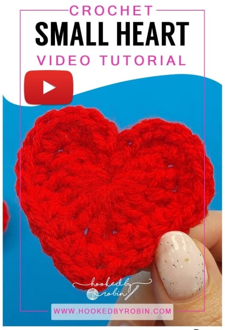 Fingers holding a little red crochet heart. Text on the image reads: Crochet small heart video tutorial, hooked by robin.