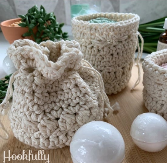 Off white crochet drawstring pouches sitting on a table. Text on the image reads: Hookfully.