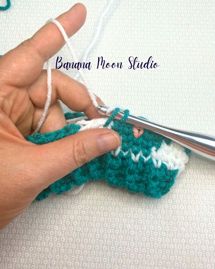 A fair isle crochet hat project in process showing how to change yarn colors. Text on the image reads: Banana Moon Studio.